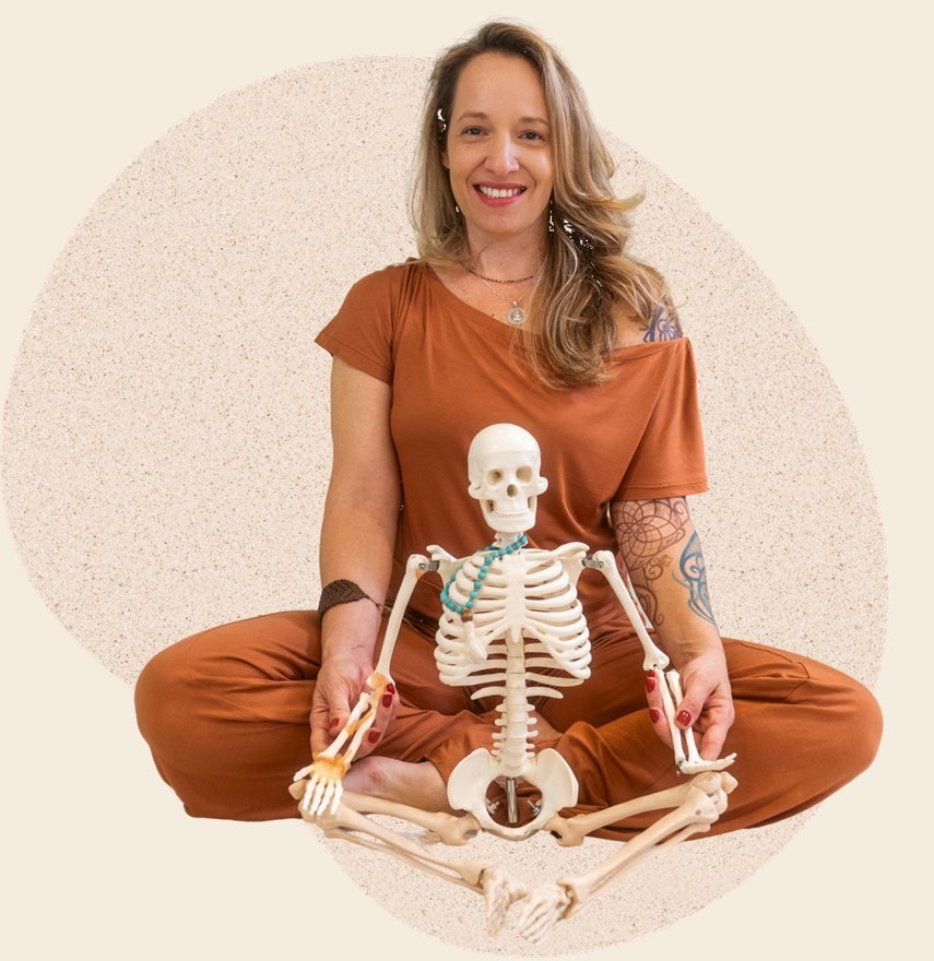 Alessandra Bertinatto sentada em posição de meditação, com um esqueleto à frente